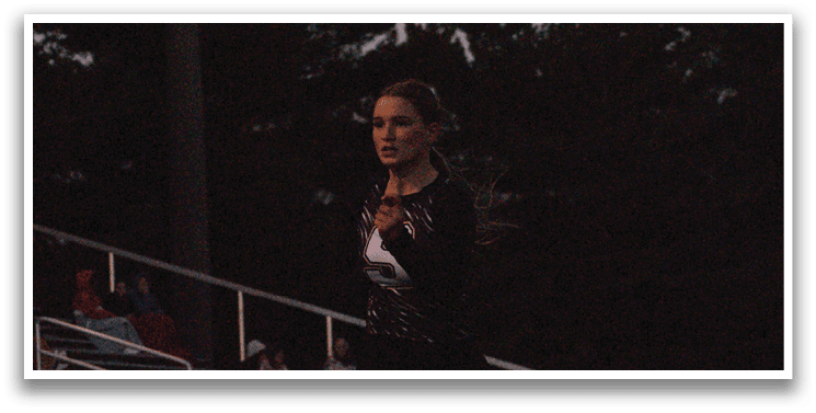 A woman in a black and white outfit is standing on a field. Contenido generado con IA
