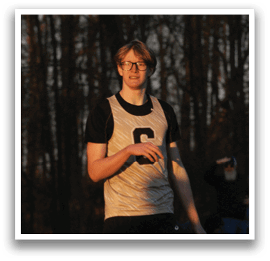 A man wearing a white and black jersey is walking on a track. Contenido generado con IA