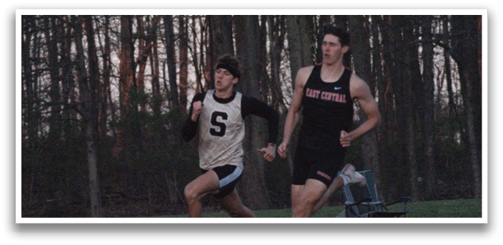 Two men are running on a track, one wearing a black shirt and the other wearing a yellow shirt. Contenido generado con IA