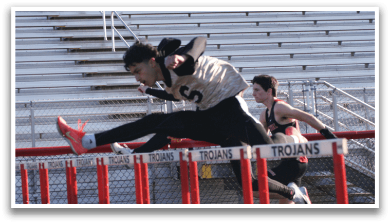Two boys are running on a track, one of them is jumping over a hurdle. Contenido generado con IA