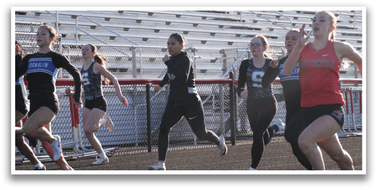 A group of girls running on a track, one wearing a red shirt. Contenido generado con IA
