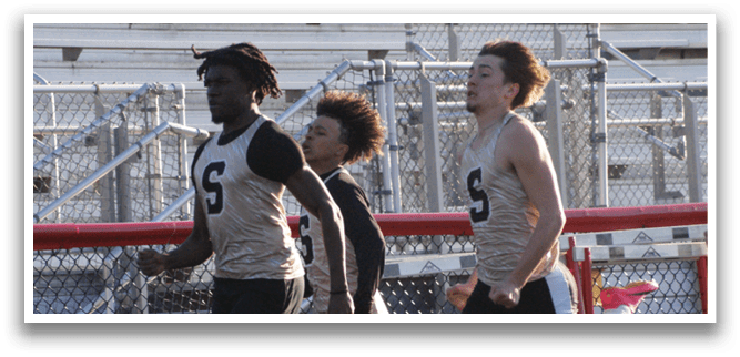 A group of young men running on a track, one of them wearing a number 5 jersey. Contenido generado con IA