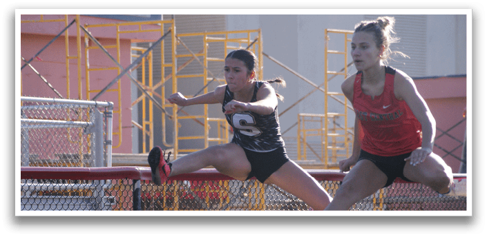 Two female athletes are jumping over a barrier. Contenido generado con IA