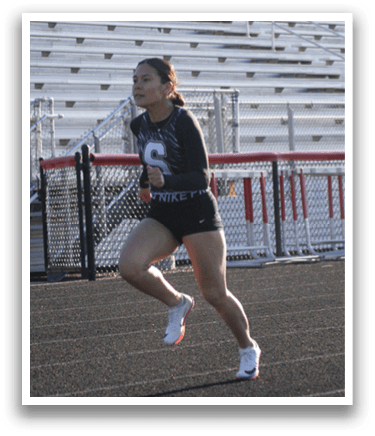 A woman is running on a track in front of a crowd of people. Contenido generado con IA