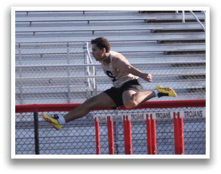 Two men are running on a track, one of them is jumping over a hurdle. Contenido generado con IA