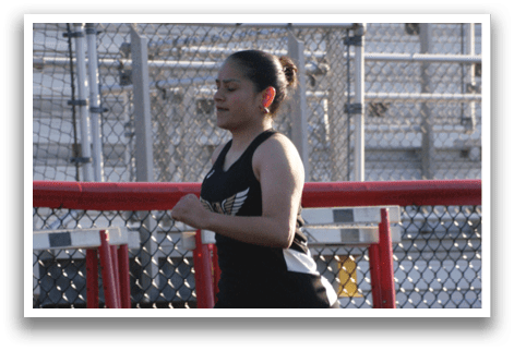 A woman is running on a track, wearing a black and white outfit. Contenido generado con IA