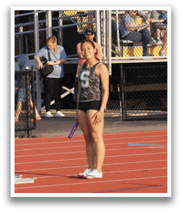 A woman is standing on a track with a frisbee in her hand. Contenido generado con IA