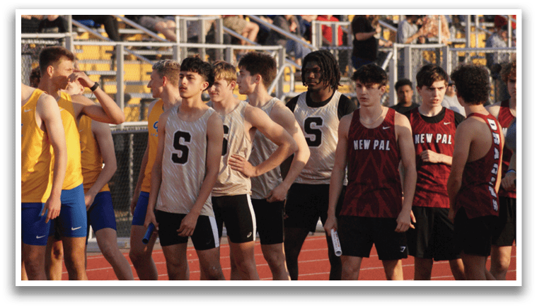 A group of young men wearing athletic uniforms stand on a track. Contenido generado con IA