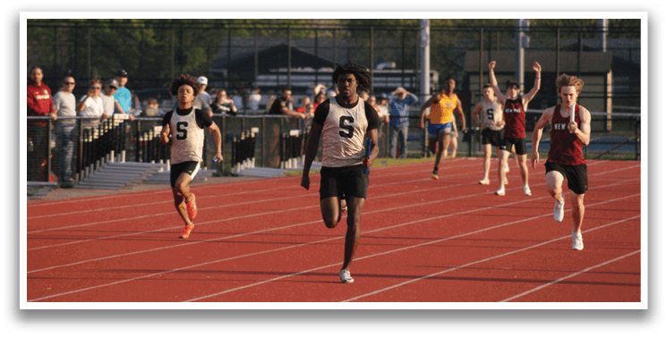 A group of people are running on a track, with one of them wearing a white shirt and black shorts. Contenido generado con IA