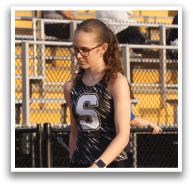 A woman wearing a black and white shirt is walking on a track. Contenido generado con IA