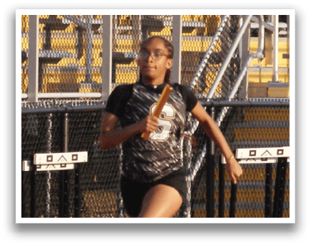 A person is running on a track in front of a crowd of people. Contenido generado con IA