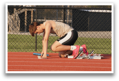 A man is kneeling on a track, holding a blue pole. Contenido generado con IA