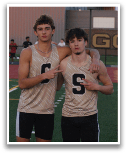 Two young men wearing track uniforms stand on a track field. Contenido generado con IA