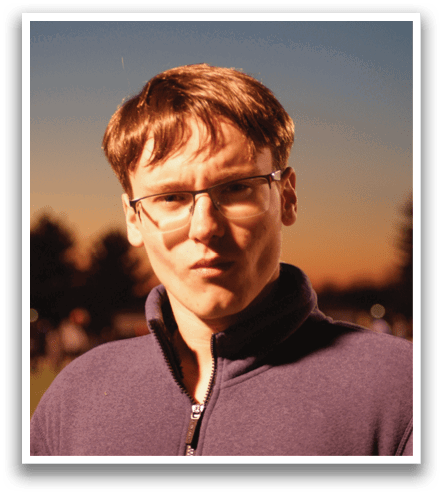 A man wearing glasses and a blue shirt is standing on a field. Contenido generado con IA