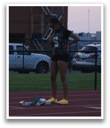 A woman is standing on a track, holding a cell phone. Contenido generado con IA