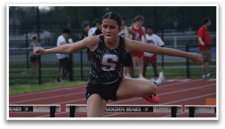 A female athlete is jumping over a hurdle on a track. Contenido generado con IA