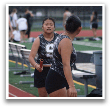 Two women are standing on a track, one of them holding a tennis racket. Contenido generado con IA
