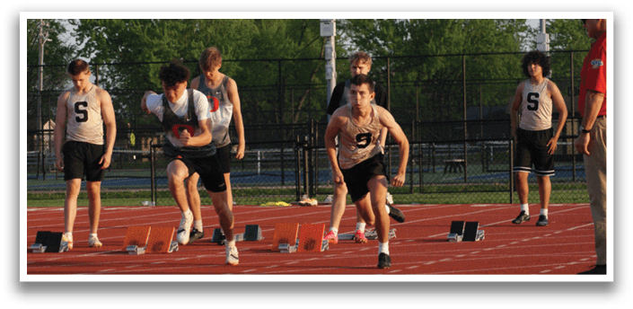 A group of young men are running on a track, with one man in the lead. Contenido generado con IA