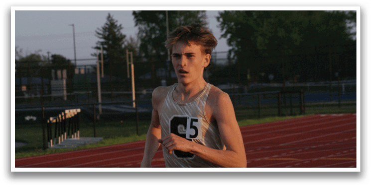 A man wearing a gold and black shirt is running on a track. Contenido generado con IA
