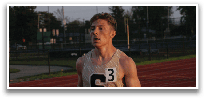 A man wearing a gold and white shirt is running on a track. Contenido generado con IA