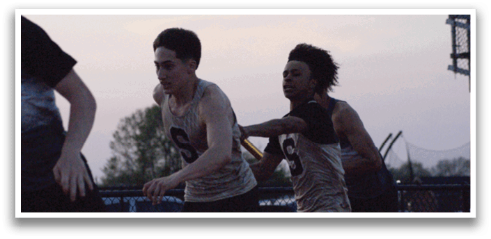 Three young men are running on a track, wearing shorts and shirts. Contenido generado con IA