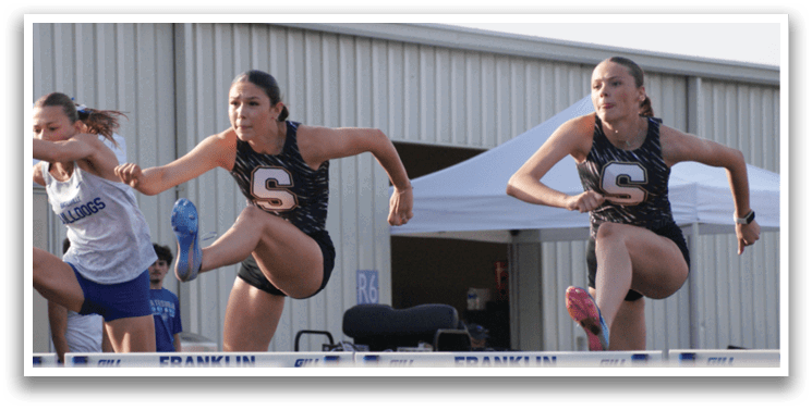 Three girls are running in a race, jumping over a barrier. Contenido generado con IA