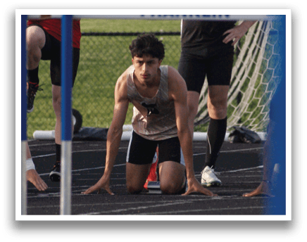 A group of young men are lined up on a track, preparing to run. Contenido generado con IA