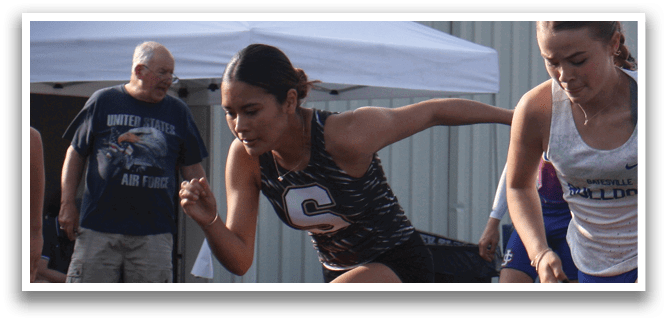A group of girls are running on a track, wearing blue and white uniforms. Contenido generado con IA