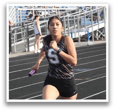 A woman is running on a track, wearing a black and white outfit. Contenido generado con IA