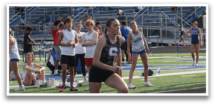 A female athlete is running on a track in front of a crowd of people. Contenido generado con IA