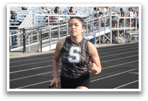 A woman wearing a black and white shirt is running on a track. Contenido generado con IA