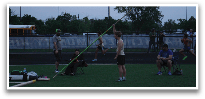 A man is jumping over a pole on a track field, while others watch. Contenido generado con IA