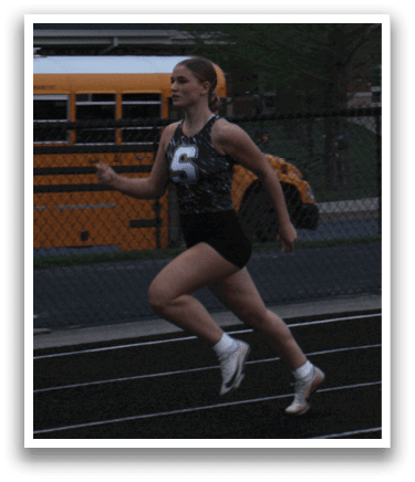 A woman is running on a track in front of a school bus. Contenido generado con IA
