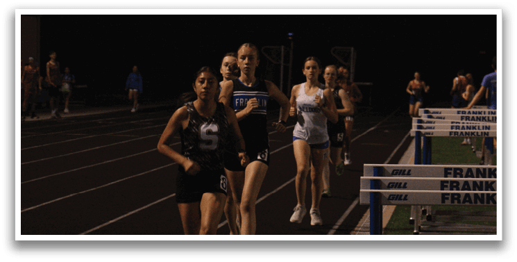 A group of people are running on a track at night. Contenido generado con IA
