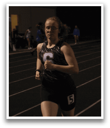 Two women are running on a track, one wearing a black shirt and the other wearing a red shirt. Contenido generado con IA