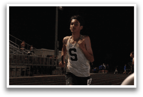 A man is running on a track in front of a crowd of people. Contenido generado con IA