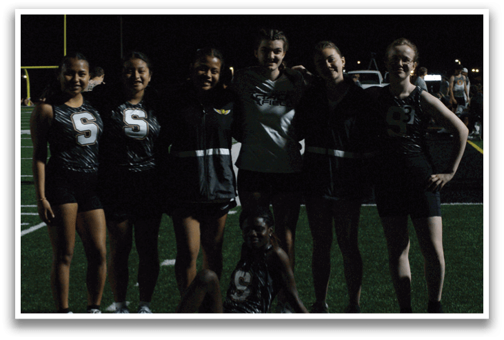 A group of young women pose for a photo on a field. Contenido generado con IA
