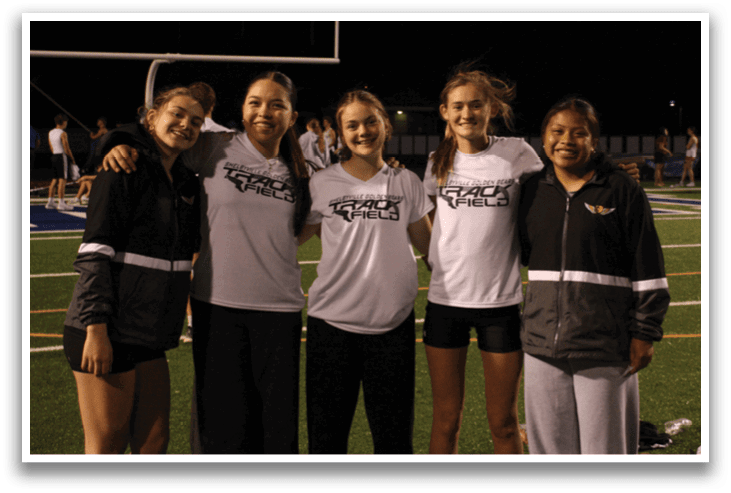 A group of young women pose for a photo on a field. Contenido generado con IA