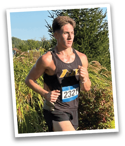 A man wearing a black tank top is running on a grassy field. Contenido generado con IA