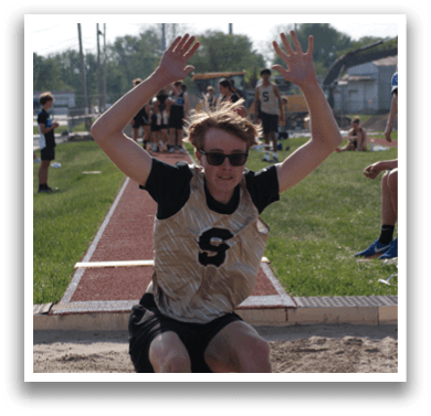 A man in a track uniform is jumping in the air. Contenido generado con IA