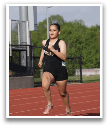 A woman is running on a track, wearing a black and white outfit. Contenido generado con IA