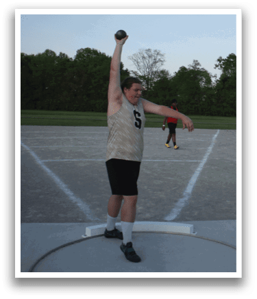 A man in a white shirt and black shorts is throwing a disc on a field. Contenido generado con IA