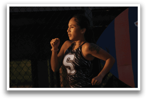 A woman wearing a black and white tank top is running on a track. Contenido generado con IA