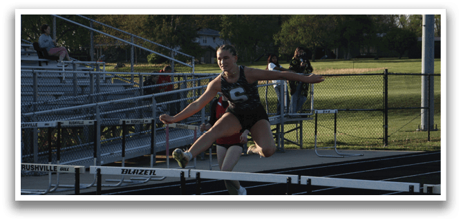 A woman is jumping over a hurdle on a track. Contenido generado con IA