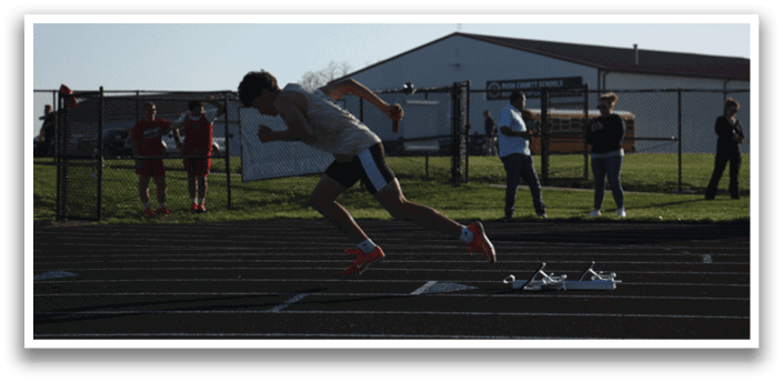 A man is running on a track, wearing a white shirt and black shorts. Contenido generado con IA
