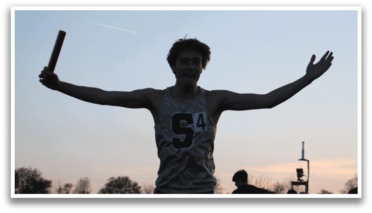 A man wearing a gold and black shirt stands in a field with his arms outstretched. Contenido generado con IA