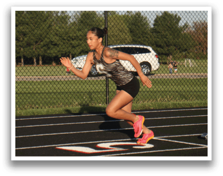 A woman is running on a track, wearing a black and white outfit. Contenido generado con IA