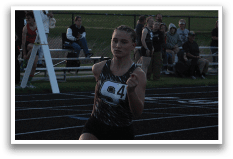 A woman is running on a track while holding a baton. Contenido generado con IA