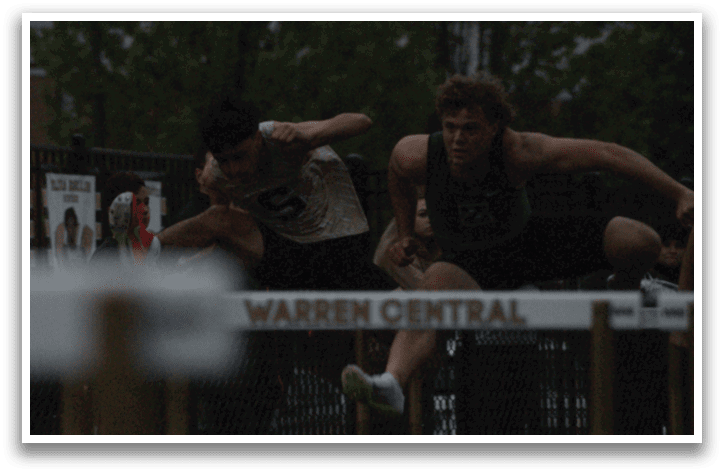 A man is jumping over a hurdle in a track meet. Contenido generado con IA