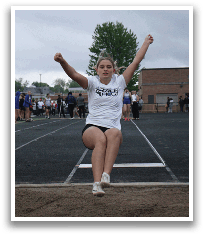 A woman is jumping in the air on a track, wearing a white shirt. Contenido generado con IA